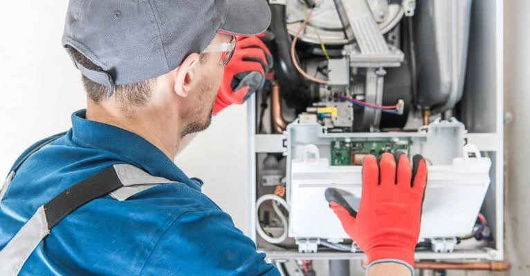 Technician working on the wiring of an indoor heating system