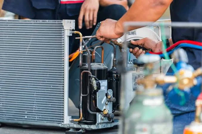 Close-up of a technician servicing air conditioner components