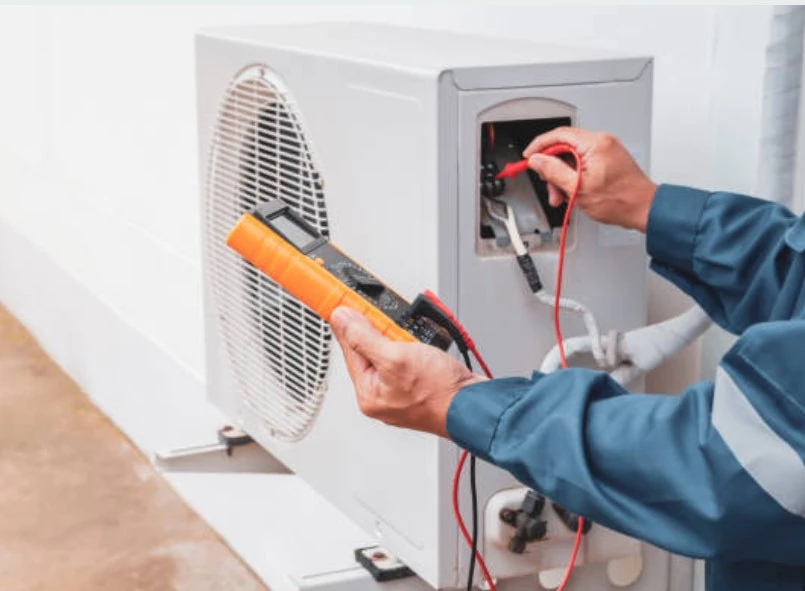 Technician testing an outdoor air conditioner with an electrical meter