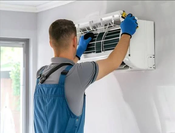 Technician cleaning the filter of a wall-mounted air conditioner