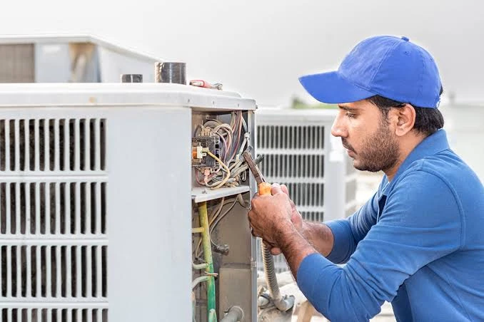 Technician repairing the wiring of an outdoor air conditioning unit